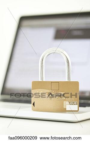 Stock Photo - Credit card and lock resting on top of laptop computer representing internet security. Fotosearch