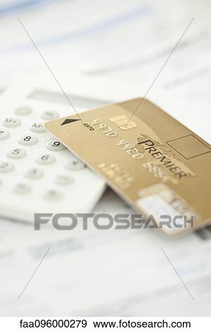 Stock Photo - Credit card resting on calculator. Fotosearch