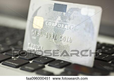Stock Image - Credit card resting on laptop computer keyboard. Fotosearch