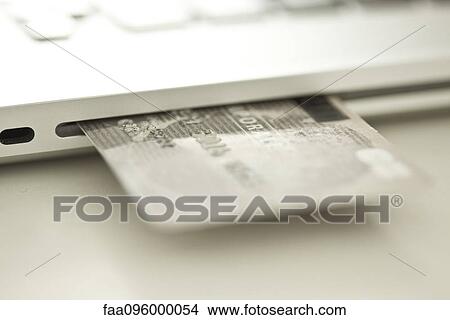 Credit card sticking out of side of laptop computer View Large Photo Image Picture - Credit card sticking out of side of laptop computer. Fotosearch
