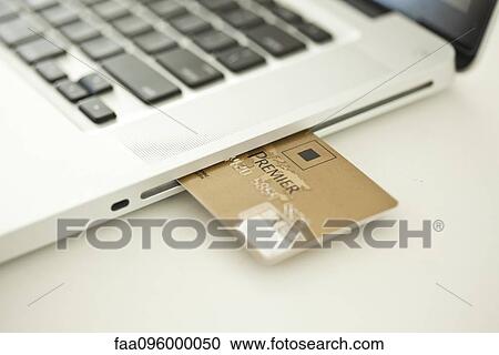 Credit card sticking out of side of laptop computer View Large Photo Image Stock Image - Credit card sticking out of side of laptop computer. Fotosearch