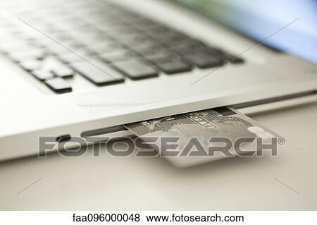 Credit card sticking out of side of laptop computer View Large Photo Image Stock Photo - Credit card sticking out of side of laptop computer. Fotosearch