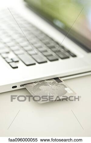 Credit card sticking out of side of laptop computer View Large Photo Image Stock Photography - Credit card sticking out of side of laptop computer. Fotosearch