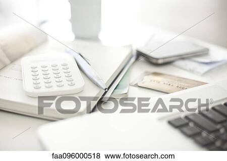 Stock Photo - Credit cards and calculator resting near laptop computer in home office. Fotosearch