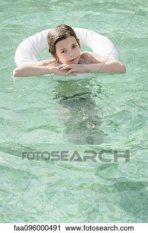 Girl floating in pool View Large Photo Image Stock Image - Girl floating in pool. Fotosearch