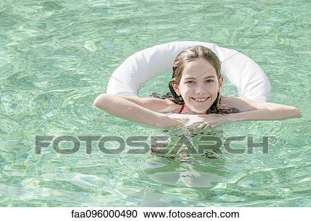Girl floating in swimming pool, portrait View Large Photo Image Stock Image - Girl floating in swimming pool, portrait. Fotosearch