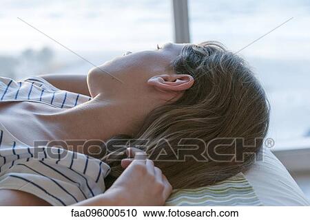 Girl lying on back, looking out window View Large Photo Image Stock Image - Girl lying on back, looking out window. Fotosearch