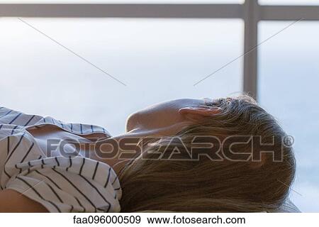 Girl lying on back, looking out window View Large Photo Image Stock Photo - Girl lying on back, looking out window. Fotosearch
