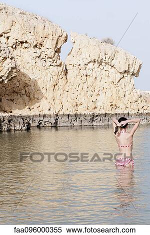 Stock Photography - Girl wading in water at the beach. Fotosearch