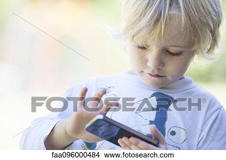 Little boy playing with smartphone View Large Photo Image Picture - Little boy playing with smartphone. Fotosearch