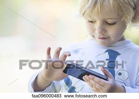 Stock Image - Little boy using smartphone. Fotosearch