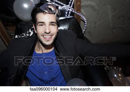 Man at party with mask on head, portrait View Large Photo Image Picture - Man at party with mask on head, portrait. Fotosearch