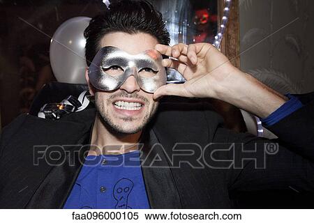 Stock Photography - Man wearing party mask, portrait. Fotosearch