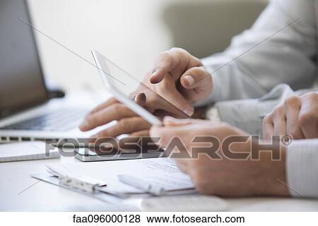Stock Photo - Men using digital tablet, cropped. Fotosearch