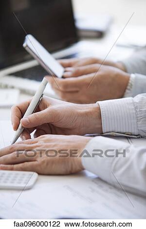 Men working at desk, cropped View Large Photo Image Stock Image - Men working at desk, cropped. Fotosearch