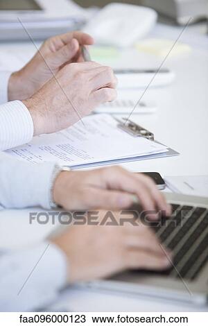 Men working at desk, cropped View Large Photo Image Stock Image - Men working at desk, cropped. Fotosearch