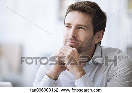 Stock Image - Mid-adult man in thought, portrait. Fotosearch