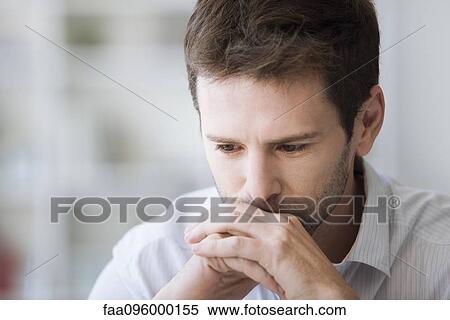 Stock Photography - Mid-adult man in thought, portrait. Fotosearch