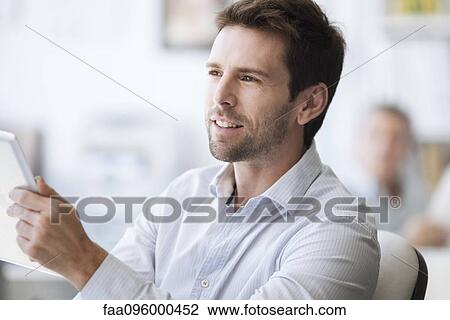 Mid-adult man using digital tablet View Large Photo Image Stock Image - Mid-adult man using digital tablet. Fotosearch