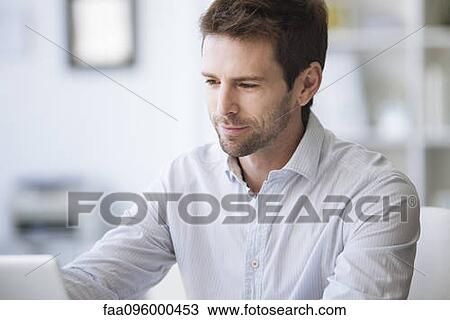 Mid-adult man using laptop computer View Large Photo Image Stock Image - Mid-adult man using laptop computer. Fotosearch