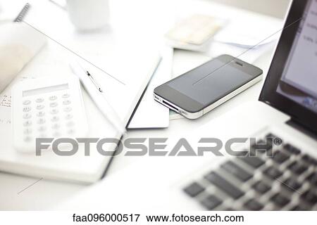 Stock Photo - Smartphone resting on desk in in home office. Fotosearch