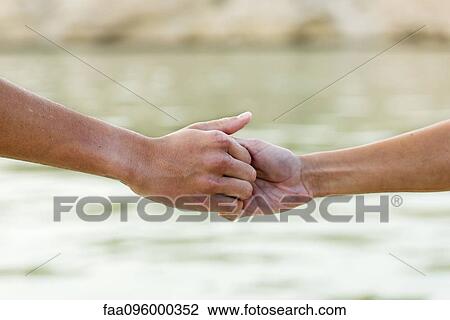 Two people holding hands, cropped View Large Photo Image Stock Image - Two people holding hands, cropped. Fotosearch