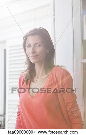 Stock Photo - Woman by open window, portrait. Fotosearch