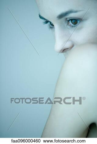 Stock Image - Woman, face against bare shoulder, portrait. Fotosearch