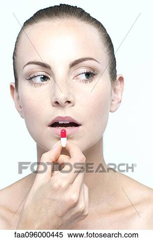 Woman preparing to take capsule View Large Photo Image Stock Photography - Woman preparing to take capsule. Fotosearch