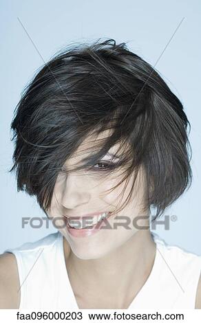 Woman smiling, hair covering one eye View Large Photo Image Stock Image - Woman smiling, hair covering one eye. Fotosearch