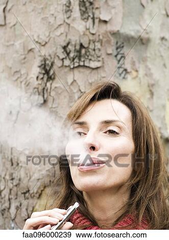 Woman smoking electronic cigarette View Large Photo Image Stock Photo - Woman smoking electronic cigarette. Fotosearch