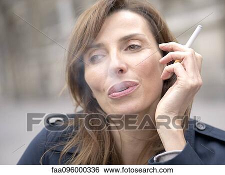 Stock Photograph - Woman smoking electronic cigarette. Fotosearch
