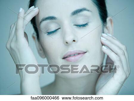 Stock Photograph - Woman touching face, eyes closed, portrait. Fotosearch