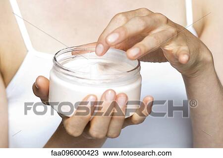 Stock Image - Woman using moisturizing cream. Fotosearch