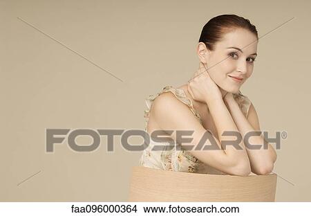Picture - Woman wearing ruffly dress, hair in bun, smiling at camera, portrait. Fotosearch