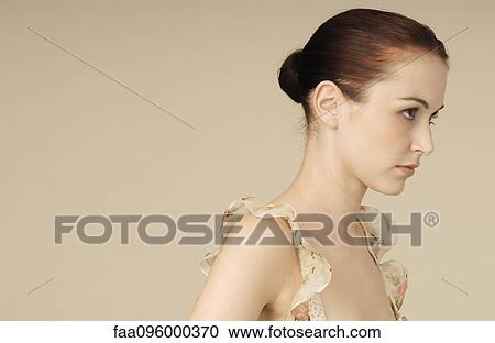 Woman wearing ruffly dress, hair in bun, portrait View Large Photo Image Stock Image - Woman wearing ruffly dress, hair in bun, portrait. Fotosearch