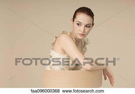 Stock Photo - Woman wearing ruffly dress, looking away, portrait. Fotosearch