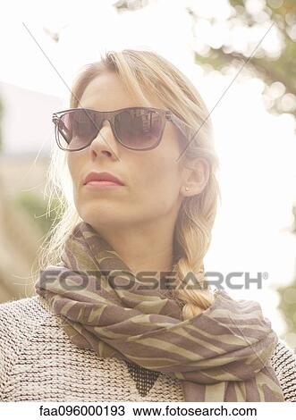 Woman wearing sunglasses and scarf, portrait View Large Photo Image Stock Image - Woman wearing sunglasses and scarf, portrait. Fotosearch
