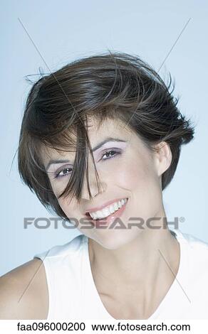 Woman with short hair, strand of hair in front of face, smiling, portrait View Large Photo Image Stock Image - Woman with short hair, strand of hair in front of face, smiling, portrait. Fotosearch