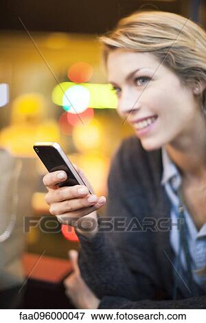 Woman with sly expression using smartphone View Large Photo Image Stock Photo - Woman with sly expression using smartphone. Fotosearch