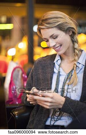 Picture - Woman with smartphone text messaging. Fotosearch