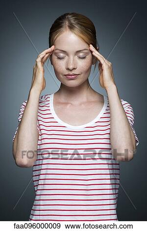 Young woman holding sides of head View Large Photo Image Stock Photo - Young woman holding sides of head. Fotosearch