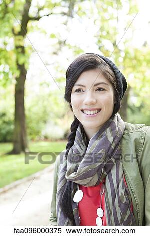 Young woman smiling in park, portrait View Large Photo Image Stock Photography - Young woman smiling in park, portrait. Fotosearch
