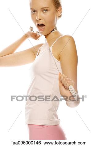 Stock Photograph - Young woman standing with measuring tape around neck and mouth open. Fotosearch
