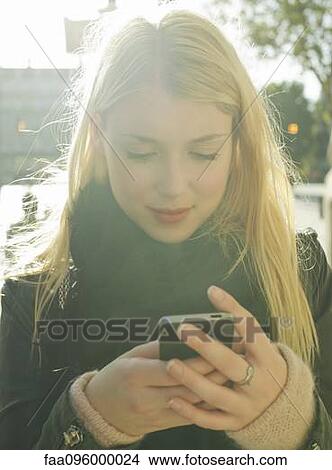 Young woman using smartphone View Large Photo Image Picture - Young woman using smartphone. Fotosearch