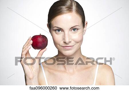 Stock Image - Young woman with apple. Fotosearch