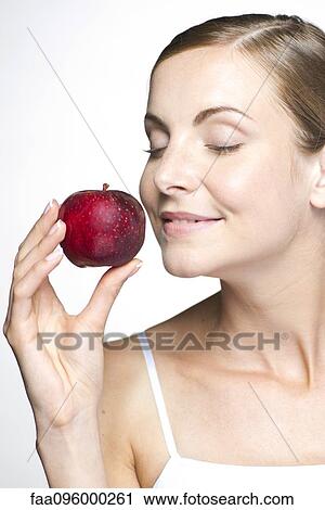 Stock Image - Young woman with apple. Fotosearch