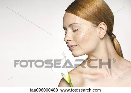 Stock Photo - Young woman with calla lily, portrait. Fotosearch