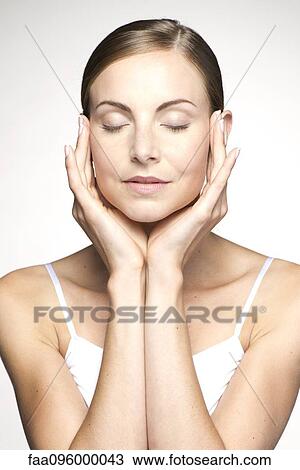 Young woman with eyes closed, touching temples View Large Photo Image Stock Image - Young woman with eyes closed, touching temples. Fotosearch