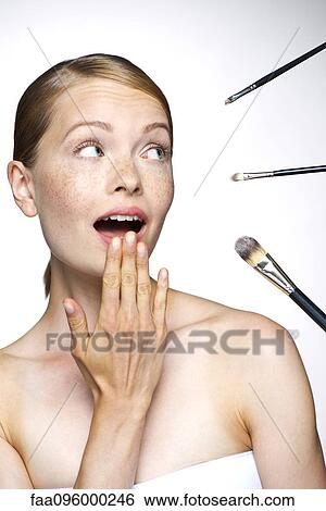 Stock Photograph - Young woman with make-up brushes. Fotosearch